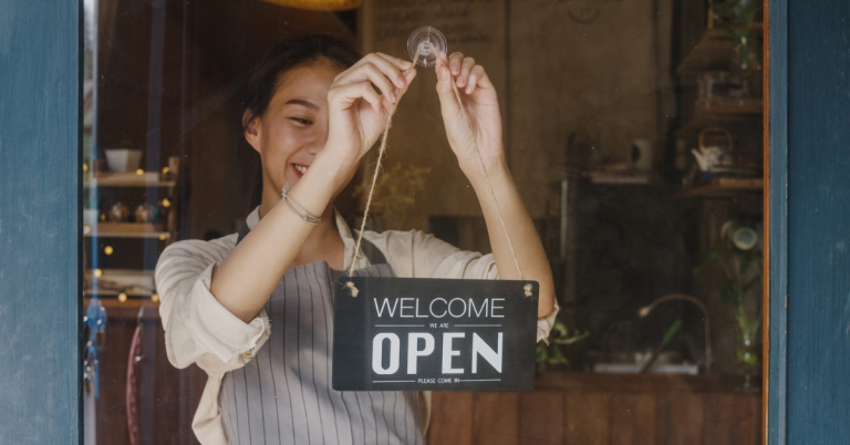 Young manager changing a sign from closed to open sign