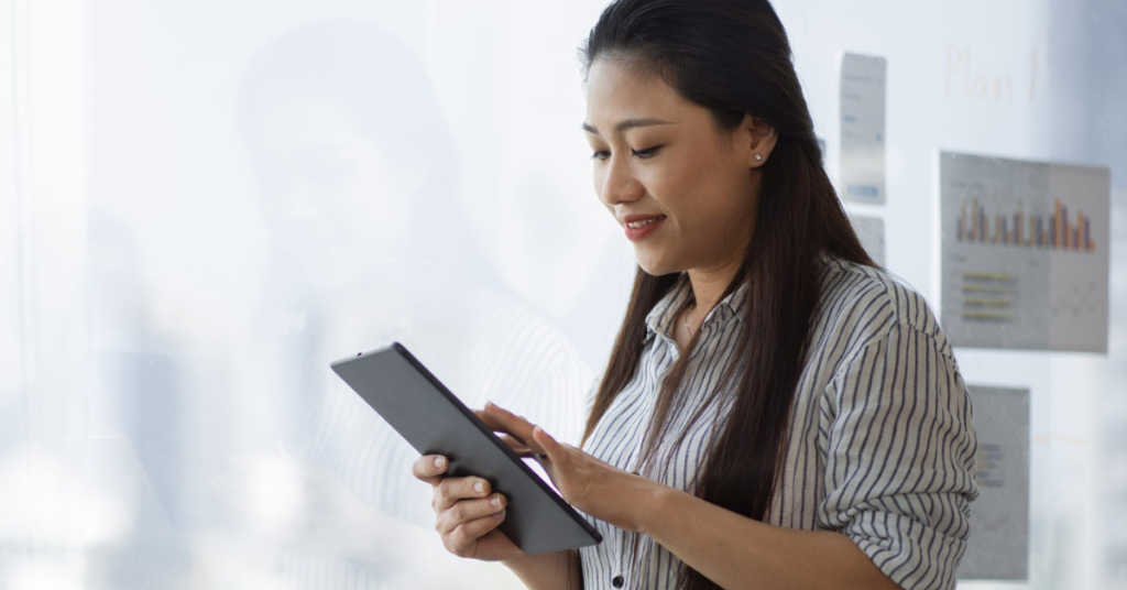 side view of smiling woman holding tablet