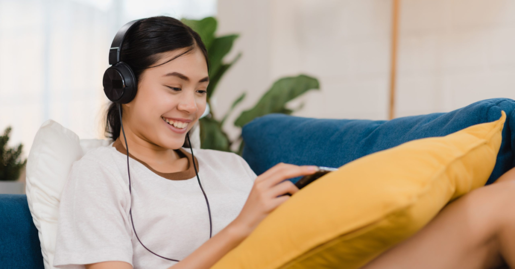 Asian woman listening to music and using tablet