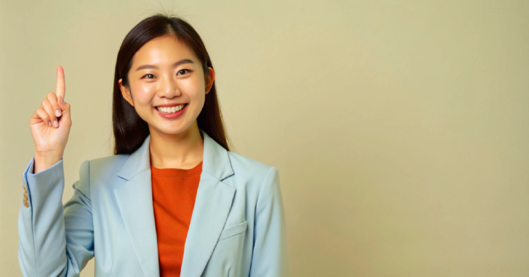 happy young Asian business woman in blazer pointing up