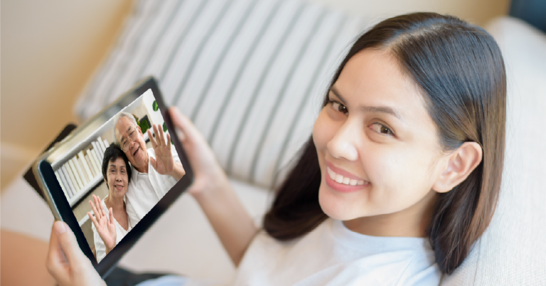 young woman using tablet to call parents