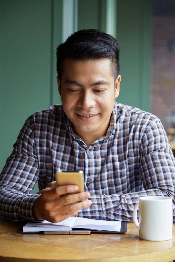 Person on their phone sitting at a coffee shop