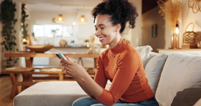 Person on the couch smiling at their phone