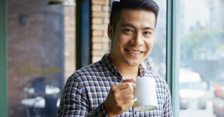 Smiling man holding a mug