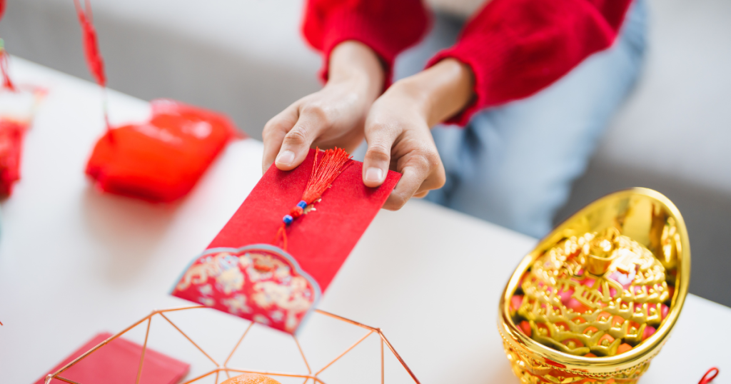 Closeup of woman offering a red envelope with both hands
