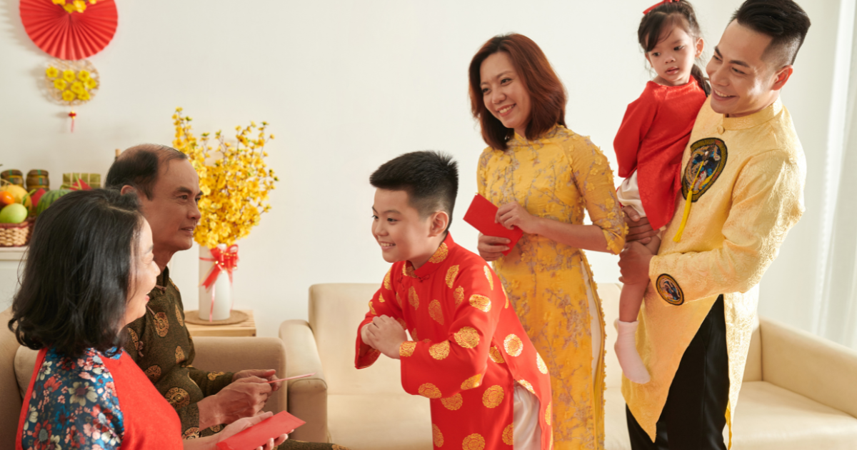 family of four lined up in front of seated grandparents, celebrating Lunar New Year